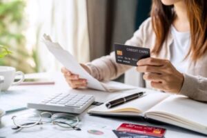 Young woman with a calculator and credit card for payment.