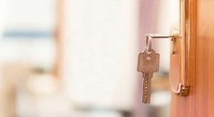 Door with a key in it open to living room