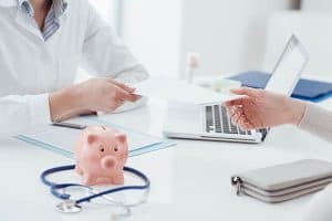 Doctor handing medical loan financing agreement to patient