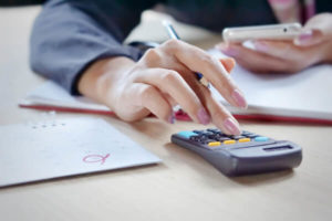 Woman calculating her debt collections bills so that she can pay them