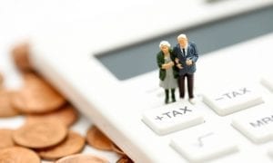 Small model of elderly couple on calculator button that says "tax"