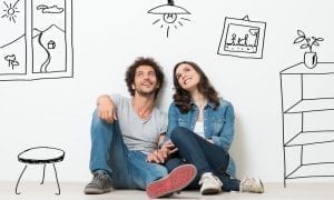 Portrait of young couple sitting on floor dreaming of future house furnishings