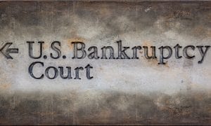 Concrete wall with arrow pointing to left with words "U.S Bankruptcy Court" engraved on it